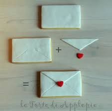 three cookies decorated like envelopes and one with a heart on it are arranged in the shape of hearts