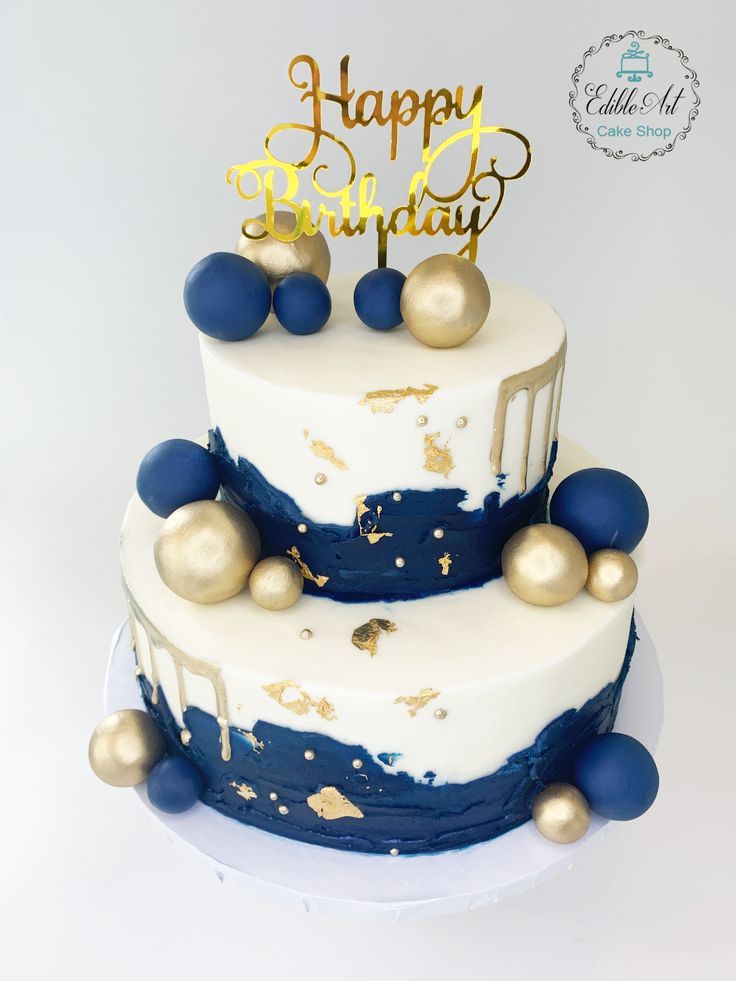 a white and blue birthday cake with gold decorations