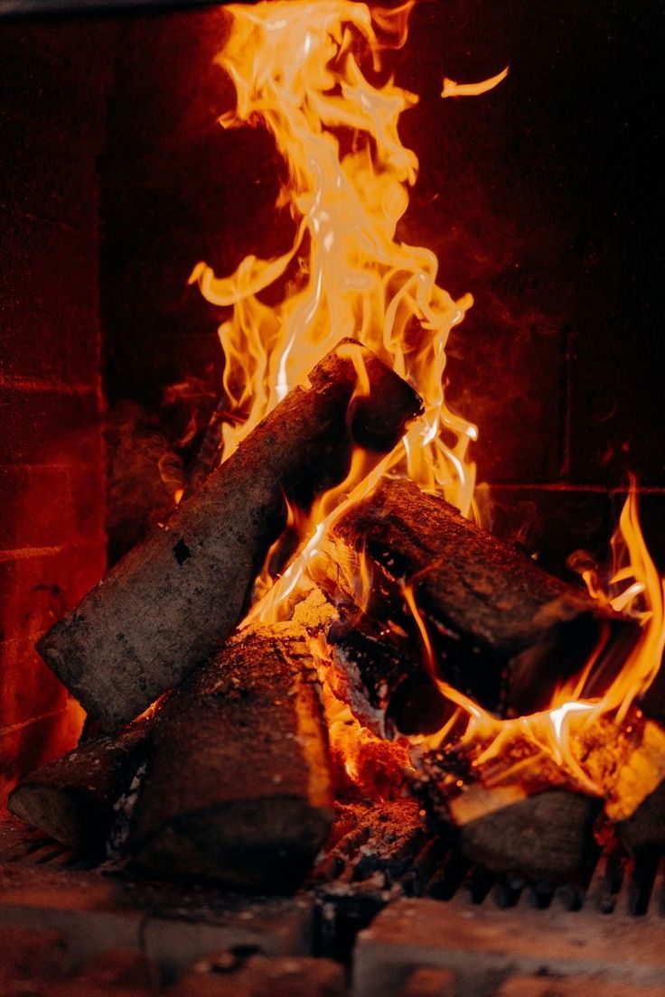 a fire burning in a brick oven with lots of flames