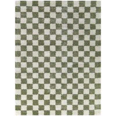 a green and white checkered rug on a white floor with an area rug in the middle