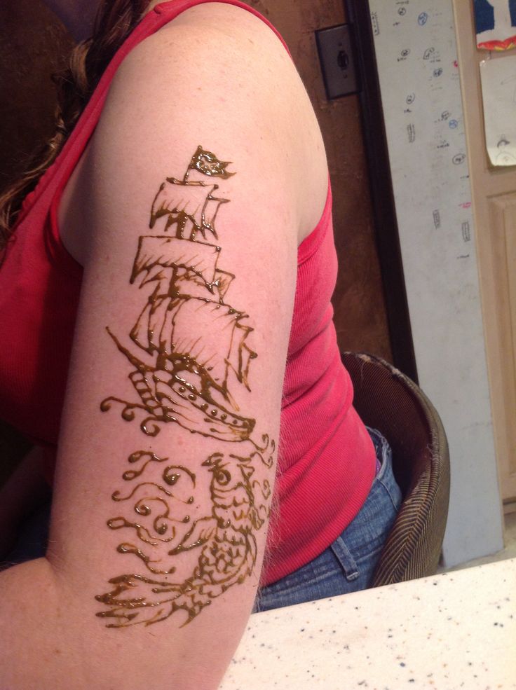 a woman with a tattoo on her arm that has a pirate ship on the side