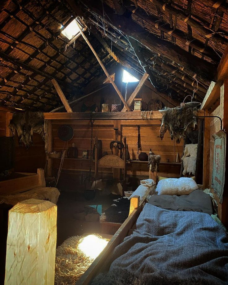 a bed in a room with wooden walls and beams on the ceiling is made of wood planks