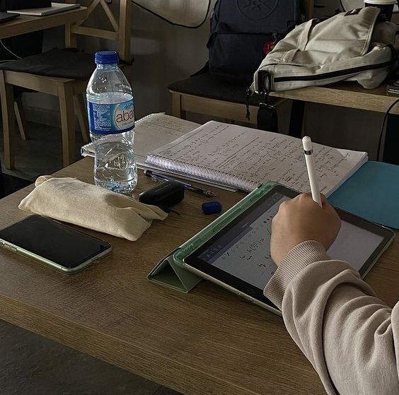 a person sitting at a desk writing on a tablet