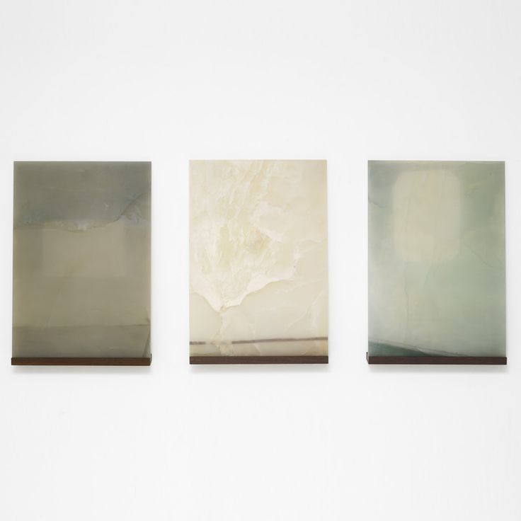 three square paintings hang on the wall