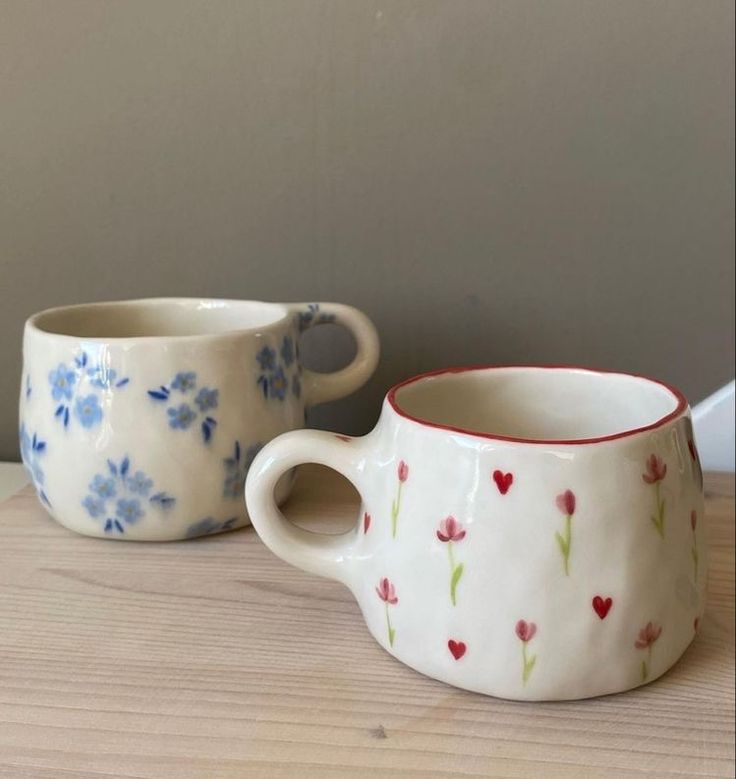 two coffee cups sitting on top of a wooden table