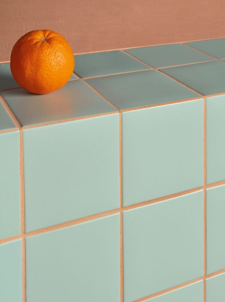 an orange sitting on top of a blue tiled counter