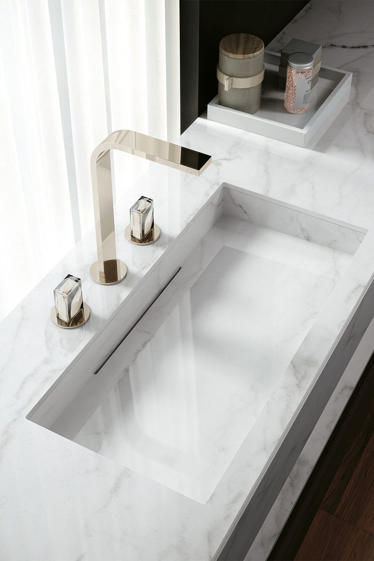 a bathroom sink with two faucets on the side and marble counter top next to it