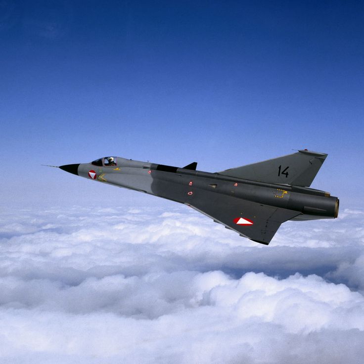 a fighter jet flying through the sky above clouds