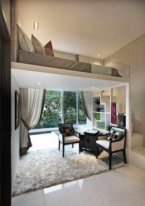 a living room filled with furniture next to a large glass window covered in white curtains