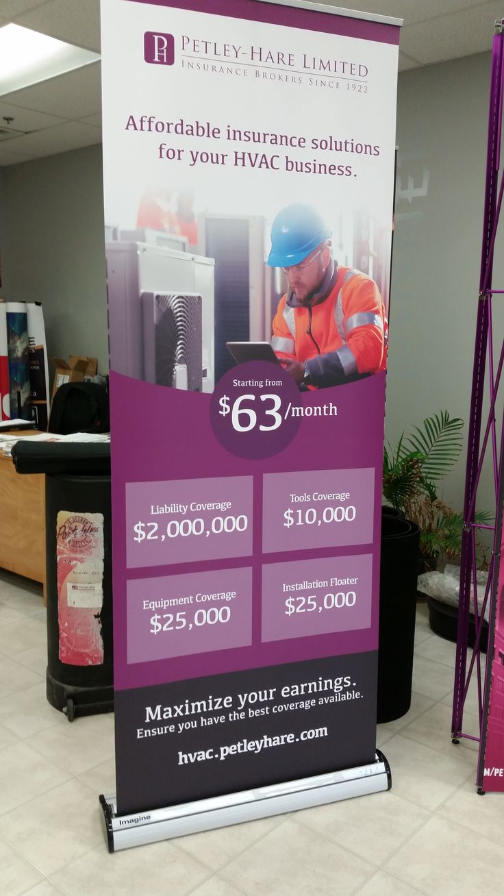 a sign advertising an hvac business in the middle of a mall floor with two workers working on it