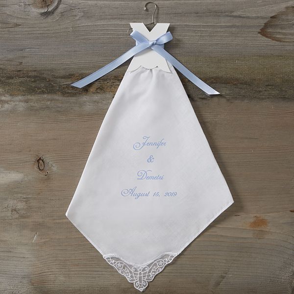 a white wedding handkerchief hanging on a wooden wall with a blue ribbon around the neck