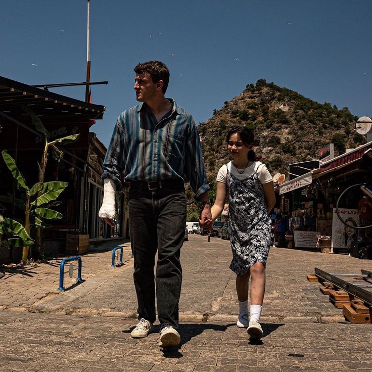 a man and woman are walking down the street