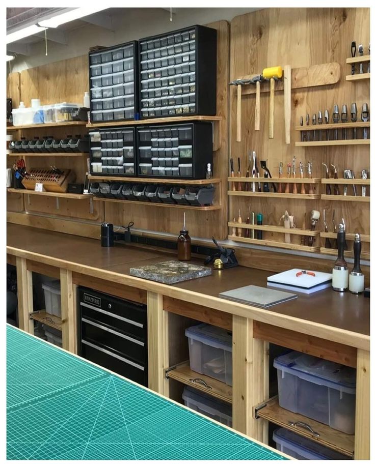 a large workbench with lots of tools on the wall and shelves above it