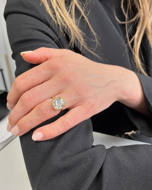 a woman's hand with a diamond ring on her left wrist, sitting at a desk