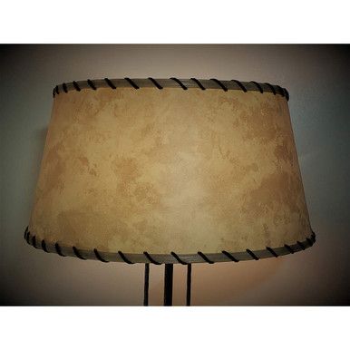 a lamp that is on a table with a light bulb turned on and the shade off