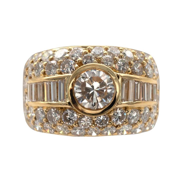 Classy cocktail ring: A genorous 18KT gold band softly domed pave set with round diamonds . In it center in a polished yellow gold frame A bezel set HRD certified center diamond and on each side of wich six bagette cut diamonds. Center diamond : 1,00 ct I VVS1 with a HRD certificate Other diamonds : 3.43 carat ( G VS +) Weight : 10.85 grams Wide Engagement Ring, 1940s Engagement Ring, 1 Carat Diamond Ring, Bling Ideas, Contemporary Engagement Rings, Statement Rings Diamond, Vintage Cocktail Ring, Beautiful Diamond Rings, Modern Engagement Rings