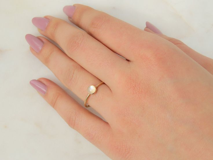 Our dainty Moonstone Ring features an absolutely stunning natural stone with reflects of blue. Moonstone is the birthstone for all our June-born babes. …………………………………. DETAILS •STONE is Natural Rainbow Moonstone measuring 5mm•BAND is 14k Gold Filled or .935 Argentium Silver •WATERPROOF rings can be worn all-day •SIZE INCLUSIVE and made to order Don't know your ring size? Ring Size Guide or Buy Ring Sizer Delicate Stacking Rings, Gold Moonstone Ring, June Birthstone Ring, Gold Gemstone Ring, Birthday Ring, Blue Moonstone, Rainbow Moonstone Ring, Argentium Silver, June Birthstone