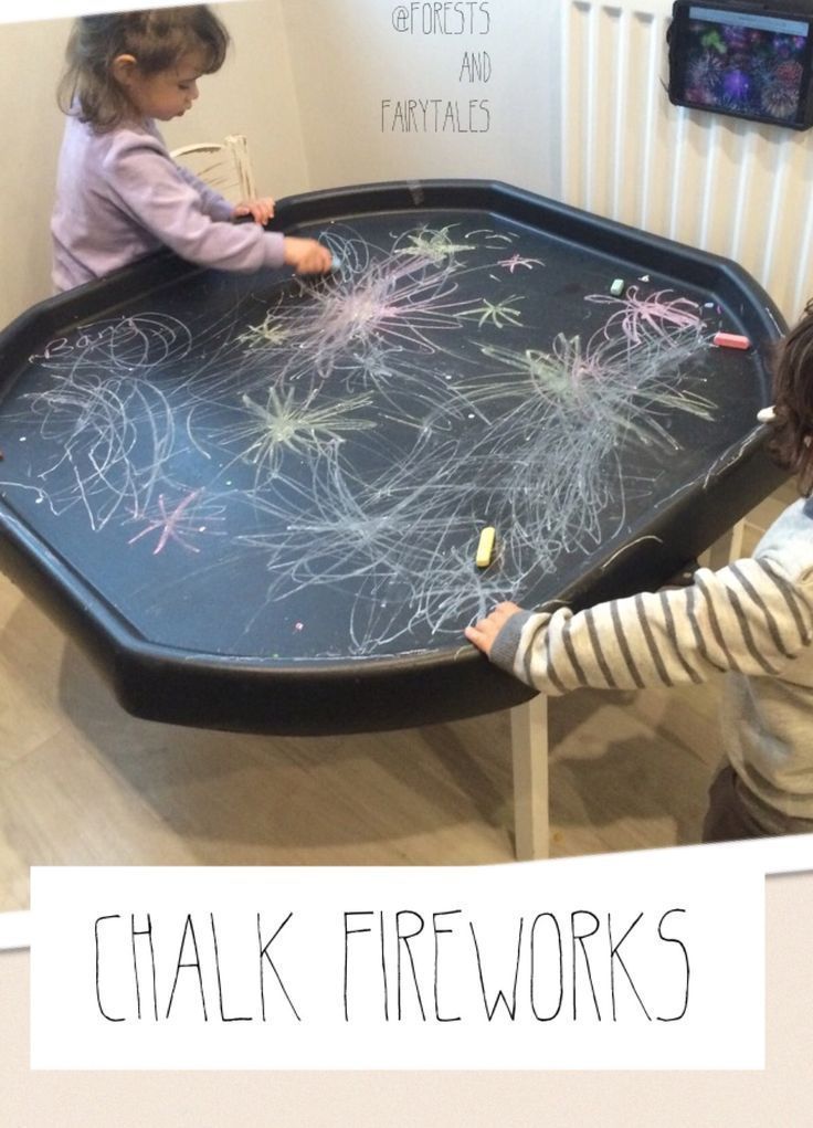 two children playing with chalk fireworks on a table