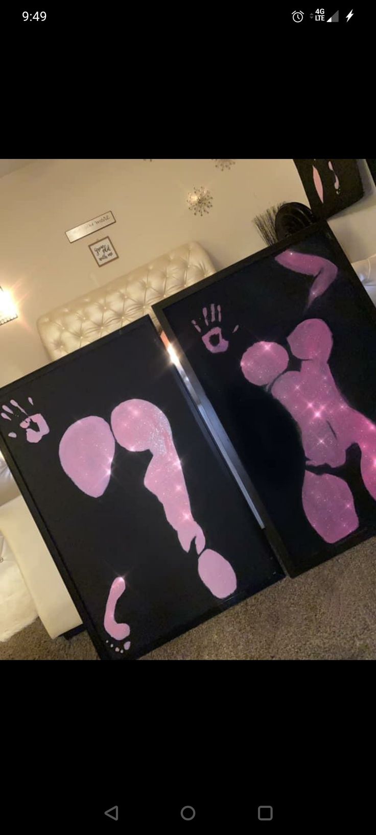 two large black paintings with pink designs on them