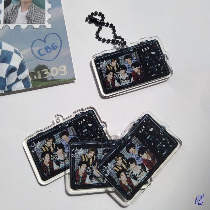 three keychains with pictures of people on them sitting next to a card holder