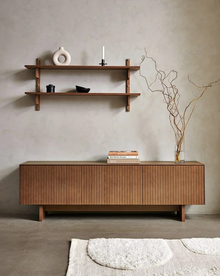 a living room with two shelves and a white rug on the floor next to it