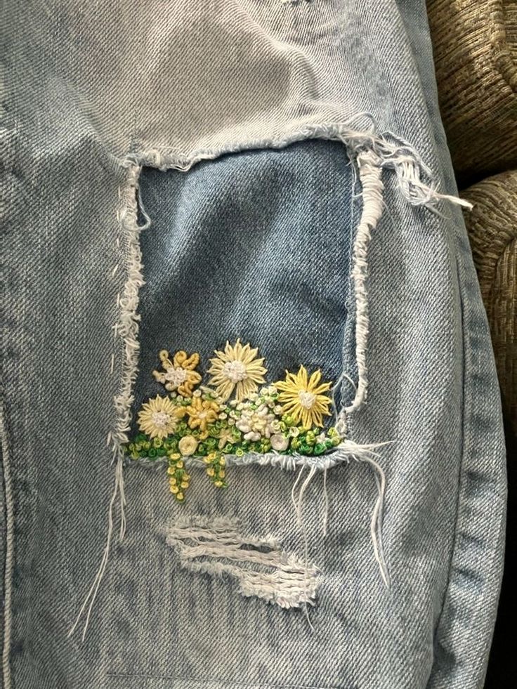 an old pair of jeans with flowers painted on them and ripped off the back pocket