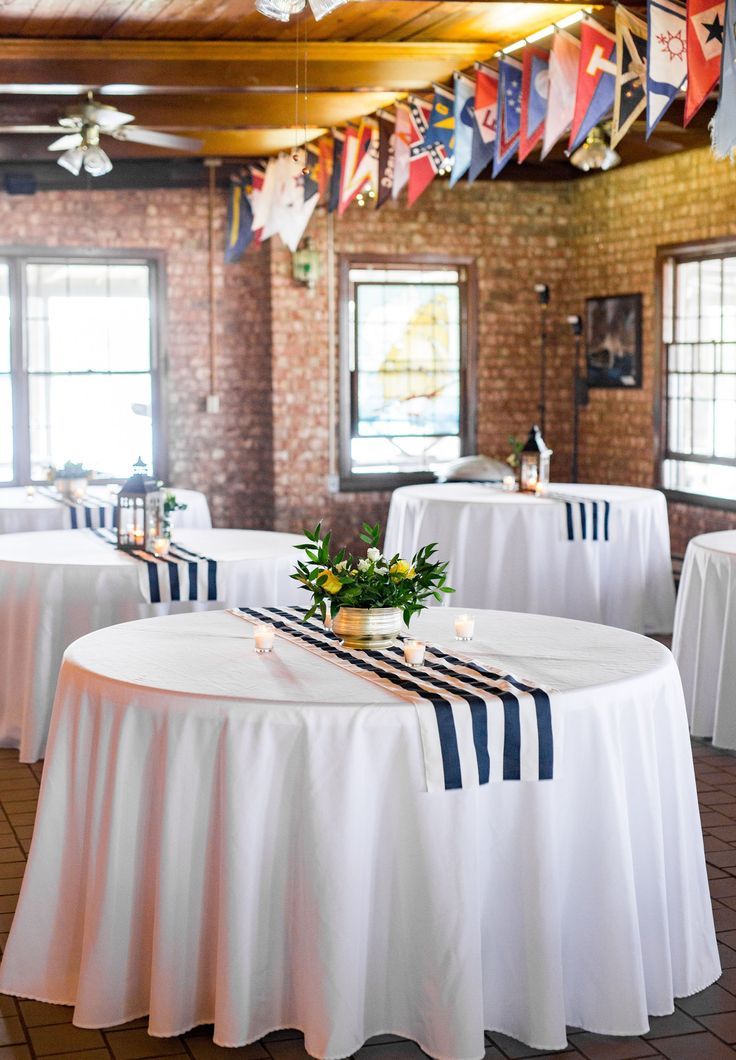 a banquet room with white tables and blue striped tablecloths