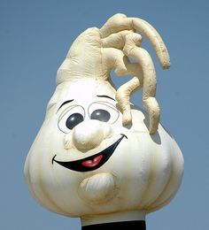 a close up of a statue of a smiling face with arms and legs