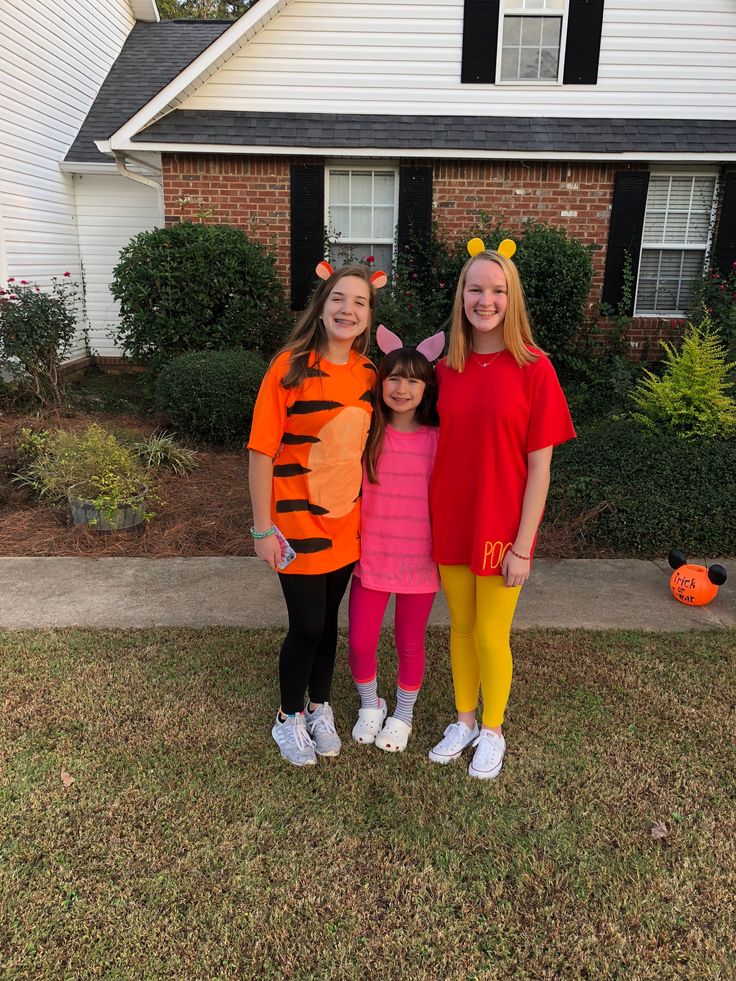 three girls dressed up as the flint family in front of a house with halloween decorations