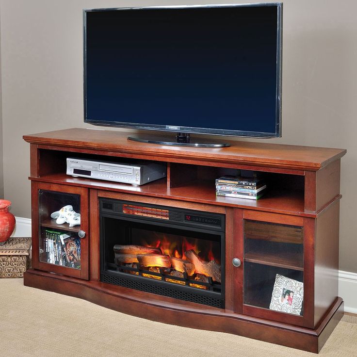 a flat screen tv sitting on top of a wooden entertainment center next to a fire place