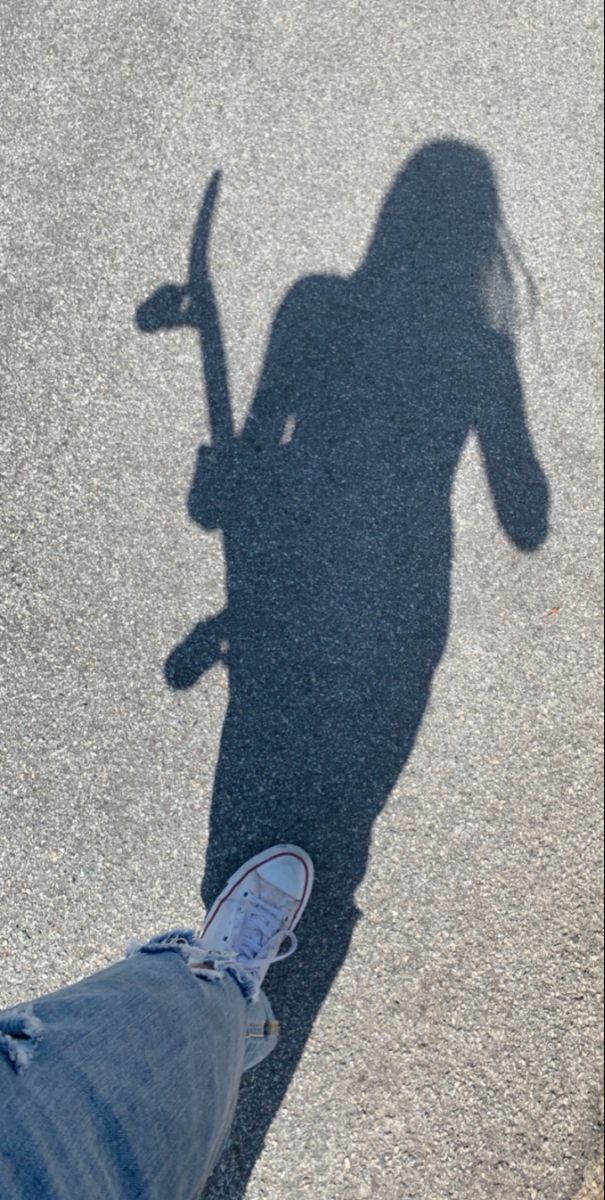 the shadow of a person holding a skateboard