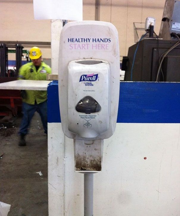 a parking meter sitting in the middle of a room next to a man wearing a hard hat