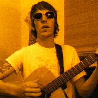 a man wearing sunglasses playing an acoustic guitar