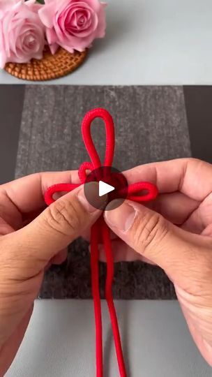 someone is making an ornament out of yarn and paper with red scissors on it