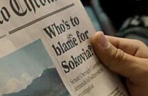 a person reading a newspaper with the caption who's to blame for souvenir?