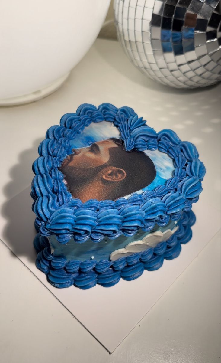 a blue cake with a picture of a man in the middle on top of it