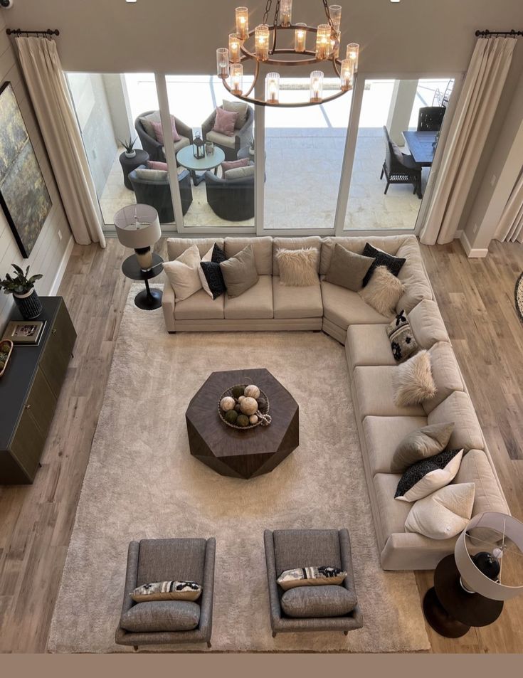 an aerial view of a living room with couches, tables and lamps in it