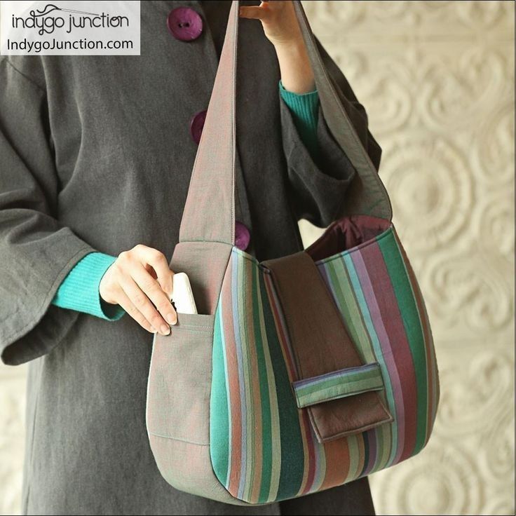 a woman is holding a multicolored purse