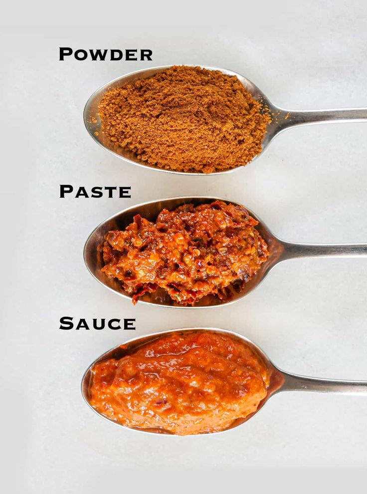 three spoons filled with different types of food on top of a white countertop