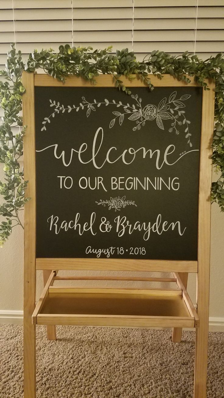 a welcome sign with greenery on it and the words welcome to our beginning rachel & brandon