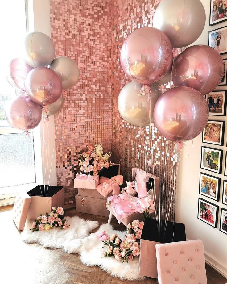 some balloons and pictures on the wall in a room with pink flowers, white fur rugs