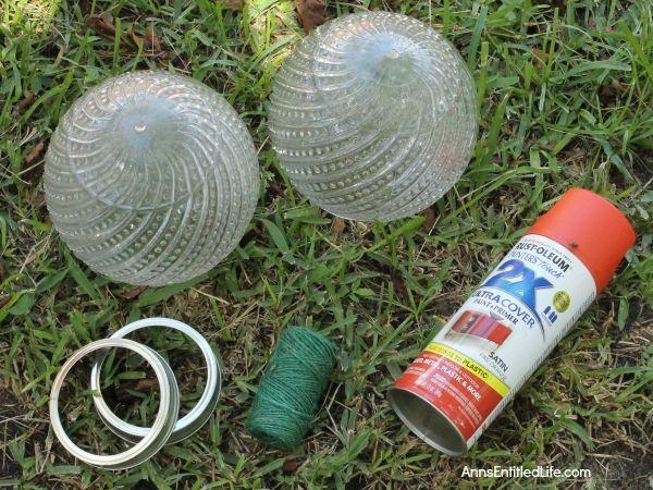 two plastic balls and some yarn on the ground next to each other in the grass