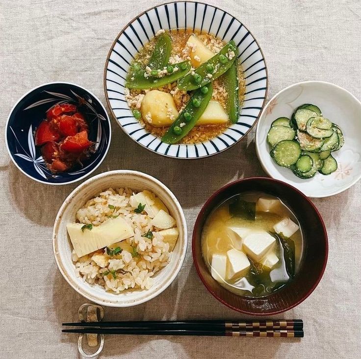 several bowls of food on a table with chopsticks