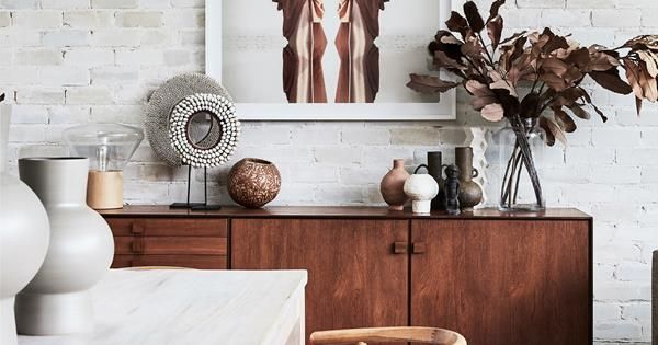 a white brick wall with vases and other decorative items on the top of it