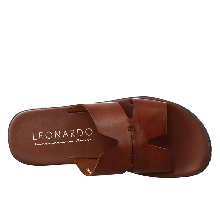 Men's H sandal



 Smooth tan vegetable tanned leather



 Rubber sole



 Padded insole



 Made in Italy




 Composition:
 Upper: 100% Leather 
Lining: 100% Leather
 Bottom: Rubber
 Insole: 100% Leather Brown Open Toe Slides In Calf Leather, Brown Calf Leather Slides With Leather Footbed, Brown Calf Leather Slides With Leather Lining, Classic Brown Calf Leather Sandals, Classic Brown Slides With Leather Sole, Classic Brown Slides With Leather Lining, Casual Brown Calf Leather Mules, Brown Leather Sole Slip-on Sandals, Brown Open Toe Slides With Branded Insole