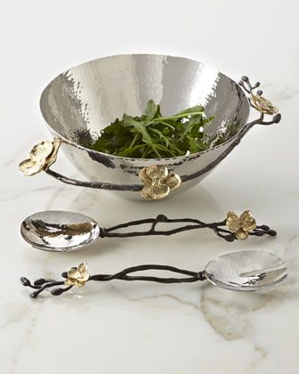 a silver bowl with spoons and flowers on it