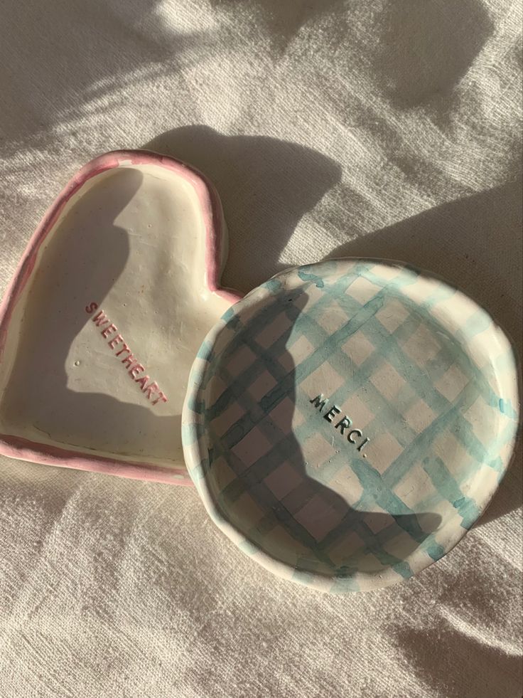 two heart shaped dishes sitting on top of a bed