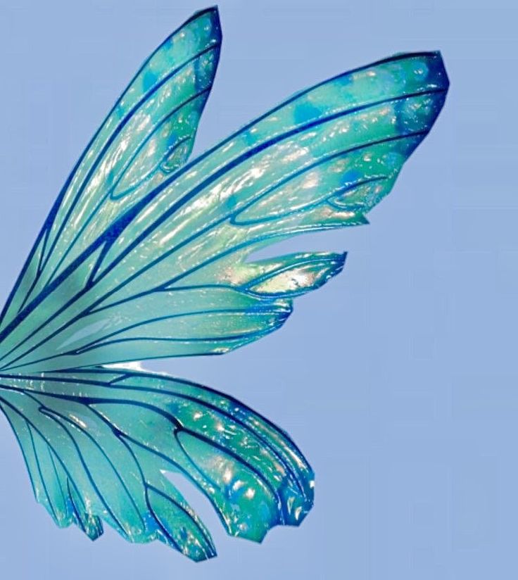 a blue and green butterfly flying through the sky