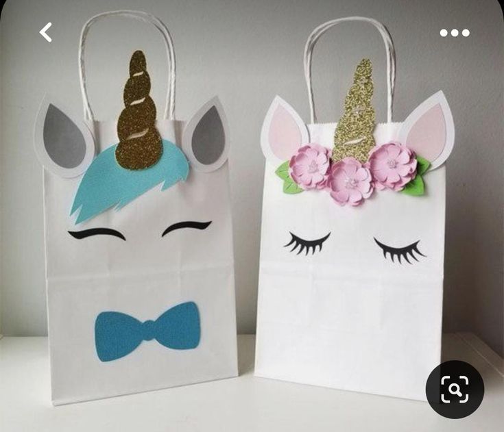 two paper bags with unicorn faces on them