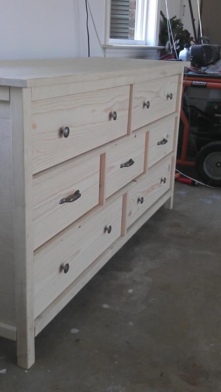 a white dresser sitting in a room next to a window